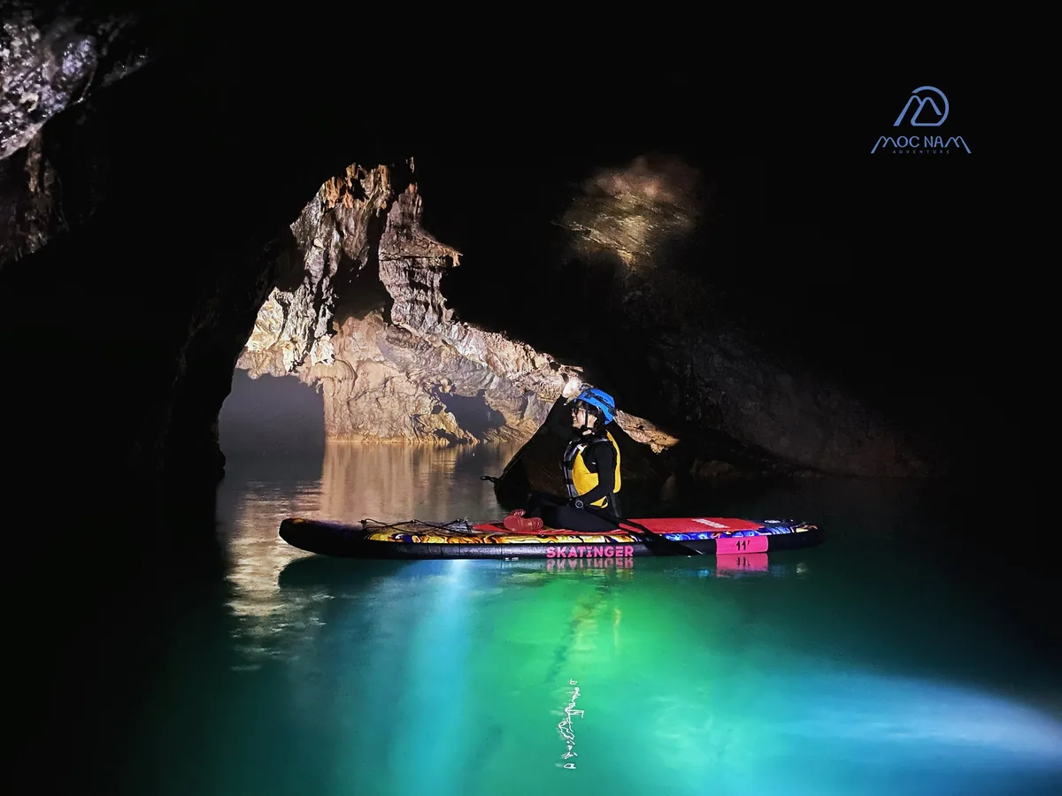 E Cave Phong Nha: Everything You Need to Know 7 SUP paddleboarding inside E Cave with turquoise water and cave formations, Phong Nha Vietnam