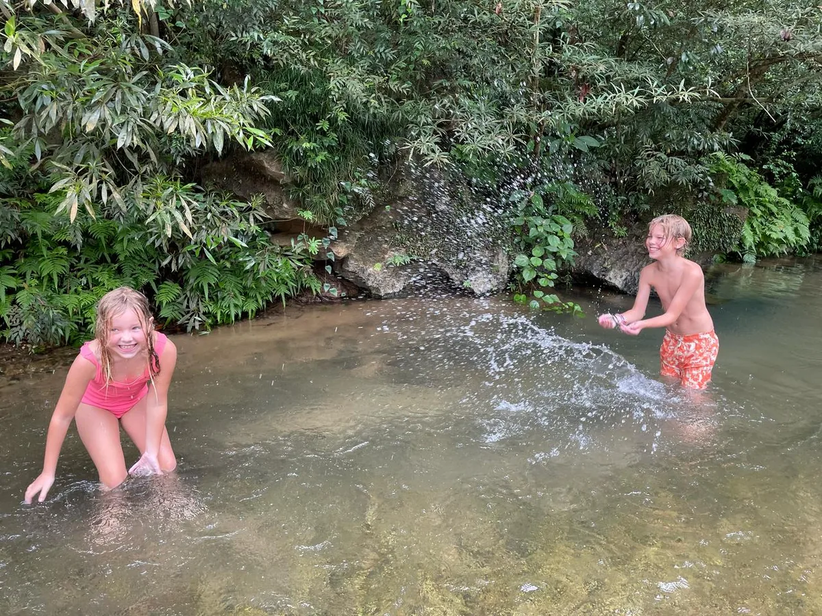 Visitors relaxing at E Cave entrance pool after cave exploration
